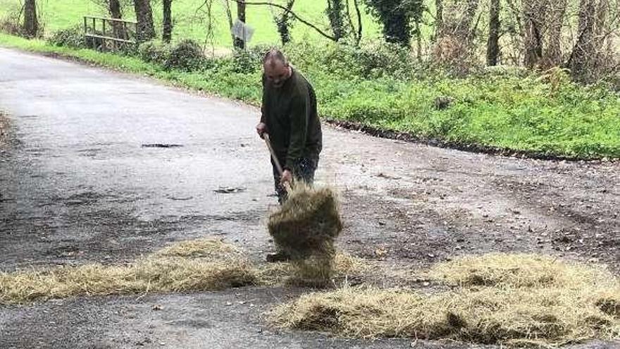 El concejal de AxA, Roberto Gómez, echando paja en los baches.