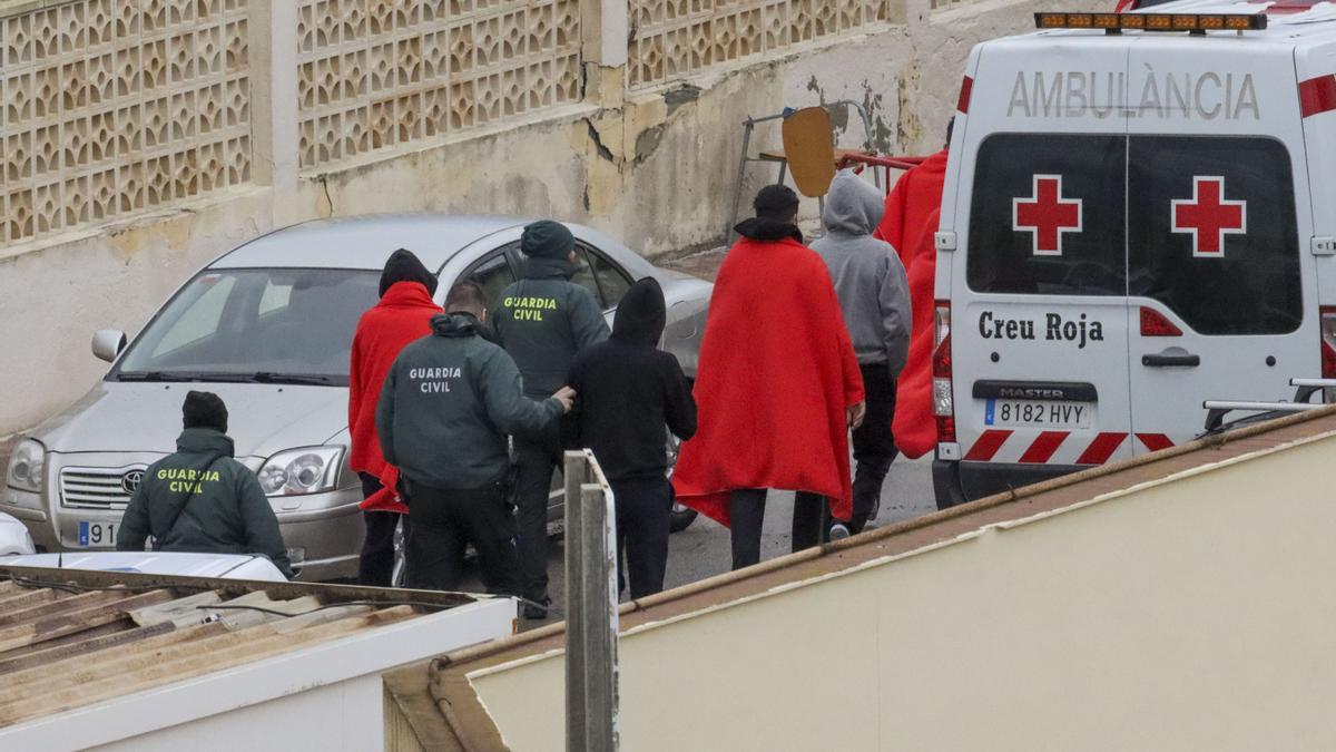 Guardias civiles y servicios de emergencias acompañan a varios inmigrantes en Ceuta.