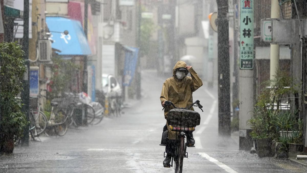 Una mujer monta en bicicleta bajo una intensa lluvia en Tokio, Japón.