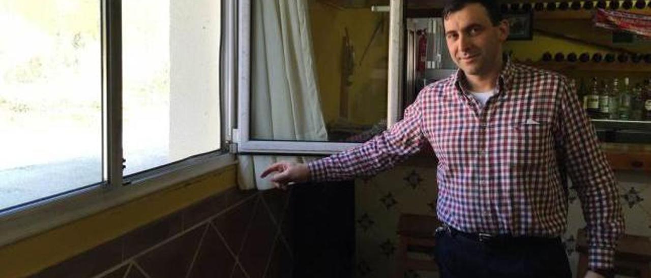 Manolo Longo muestra la ventana por la que entraron los cacos para robar la tragaperras, ayer, en su restaurante de Cangas de Onís.