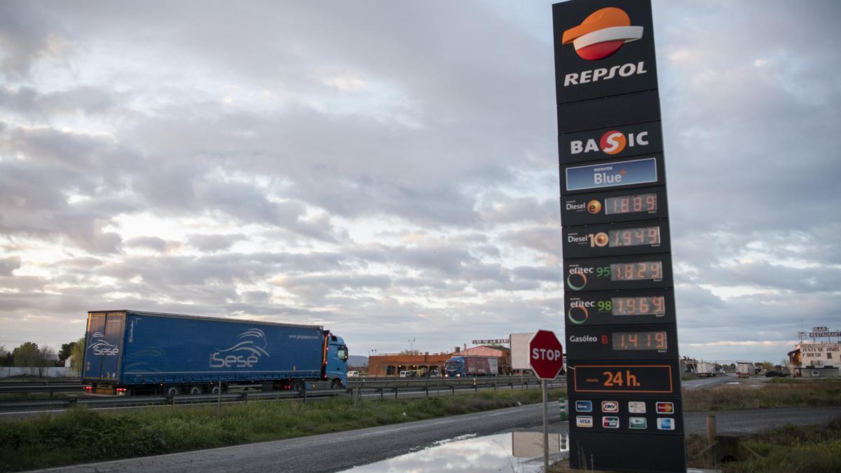 Un camión pasa al lado de una gasolinera.