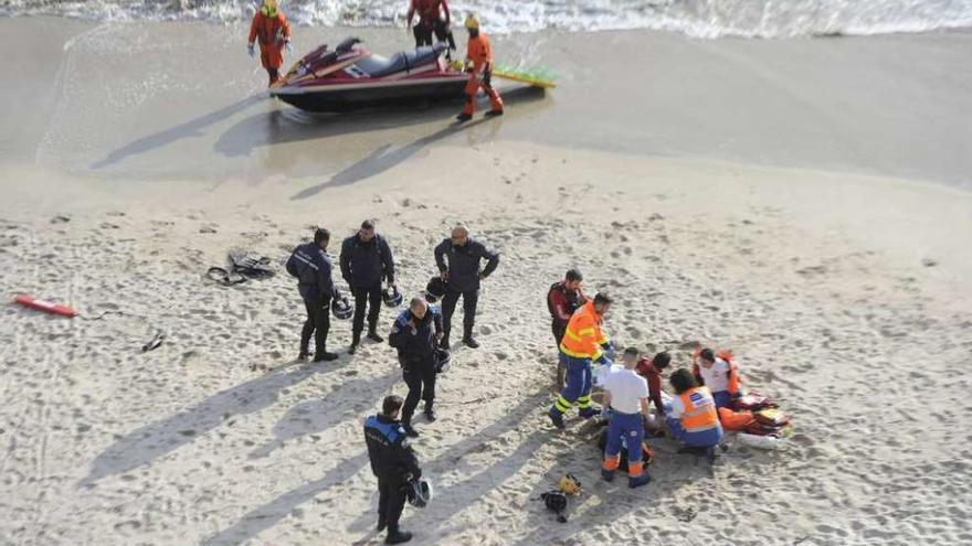 Miembros de los equipos de emergencia intentan reanimar al deportista en la playa del Matadero.