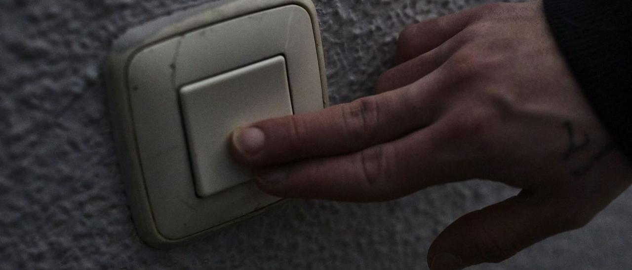 Una persona pulsa un interruptor de la luz. | Jesús Hellín