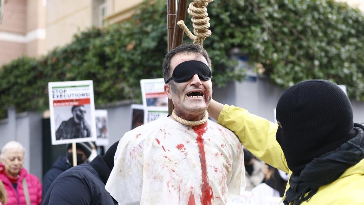 Varios manifestantes simulan una ejecución durante la manifiestación en frente de la embajada de Irán este sábado en Madrid.