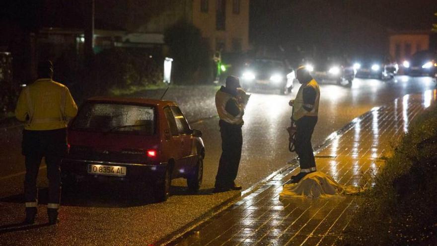 Agentes de la Guardia Civil, ayer, en Nubledo, junto al cadáver y el coche implicado en el accidente.