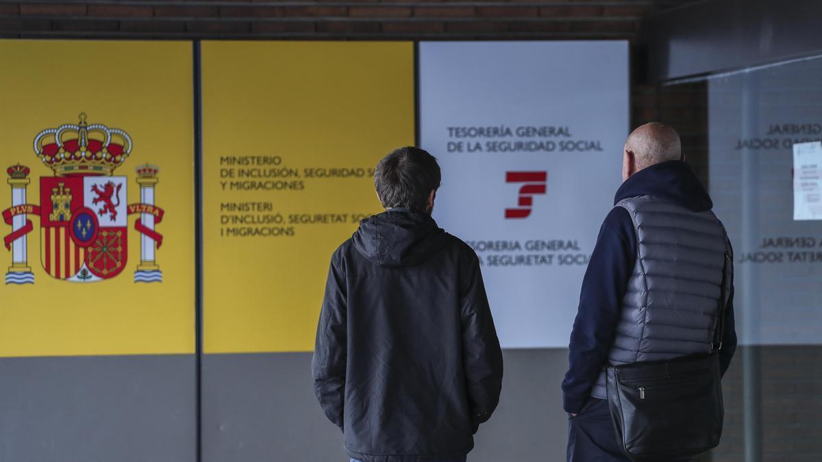 Dos personas por fuera de una oficina del Instituto Nacional de la Seguridad Social (INSS).