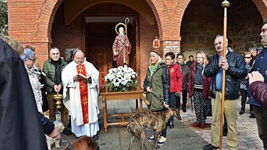 El párroco con las sagradas escrituras a las puertas de la iglesia.