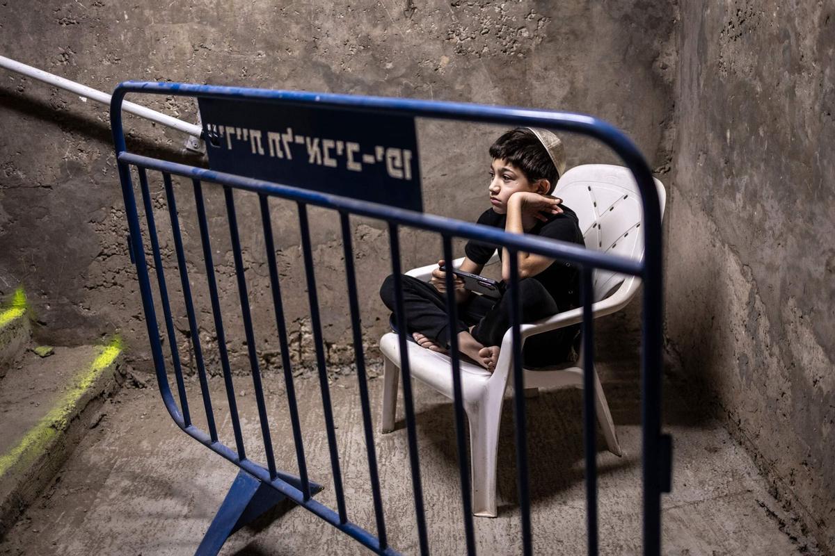 A child looks on as he waits in an underground parking used as a bomb shelter during an alert in Tel Aviv on March 10, 2026. Israeli Defence Minister Israel Katz said on March 11, that the joint bombing campaign with the US against Iran would go on "as long as necessary", insisting the strikes had inflicted heavy casualties on Tehran's forces. (Photo by OLYMPIA DE MAISMONT / AFP) / Attention editors: AFP covers the war in the Middle East through its extensive regional network, including bureaus in Tehran, Jerusalem and several neighboring countries.Since the start of the conflict, journalists have been working under increasingly restrictive conditions. Authorities in several countries have limited reporters’ movements, photo and live video coverage from sensitive locations. Some governments and armed groups have banned images of missile or drone strikes and other security-related sites. /. SEE CAPTION FOR MORE INFORMATION / Attention editors: AFP covers the war in the Middle East through its extensive regional network, including bureaus in Tehran, Jerusalem and several neighboring countries.Since the start of the conflict, journalists have b