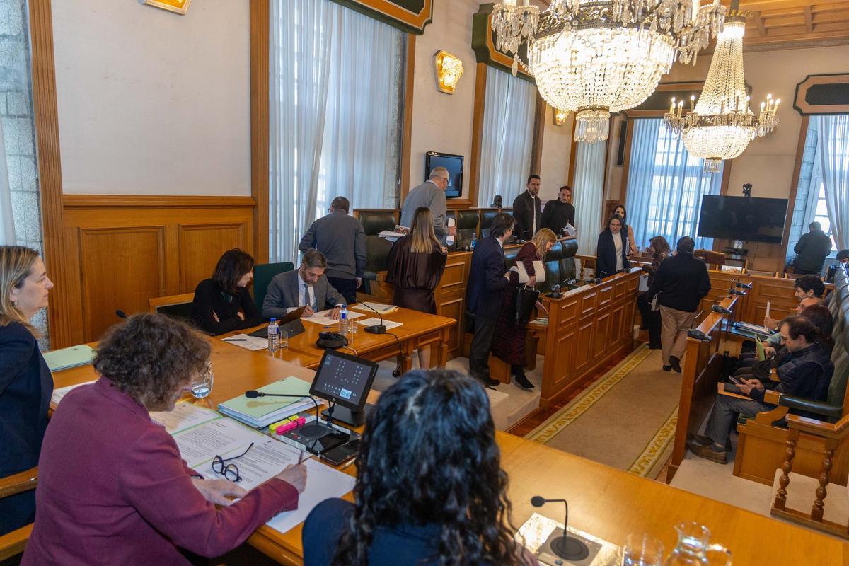 Los miembros de la Corporación municipal de Santiago se sitúan en sus asientos, en los instantes previos al pleno de este jueves