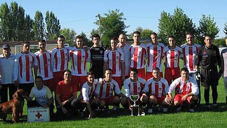 El equipo campeón posa con el trofeo que le acredita como tal.