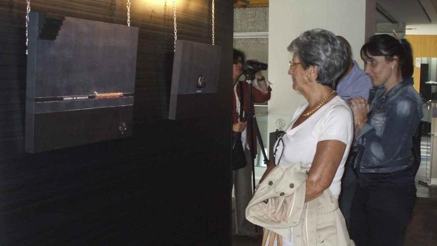 Invitados a la inauguración de la exposición admiran dos de las esculturas de pared de Olga Antón.