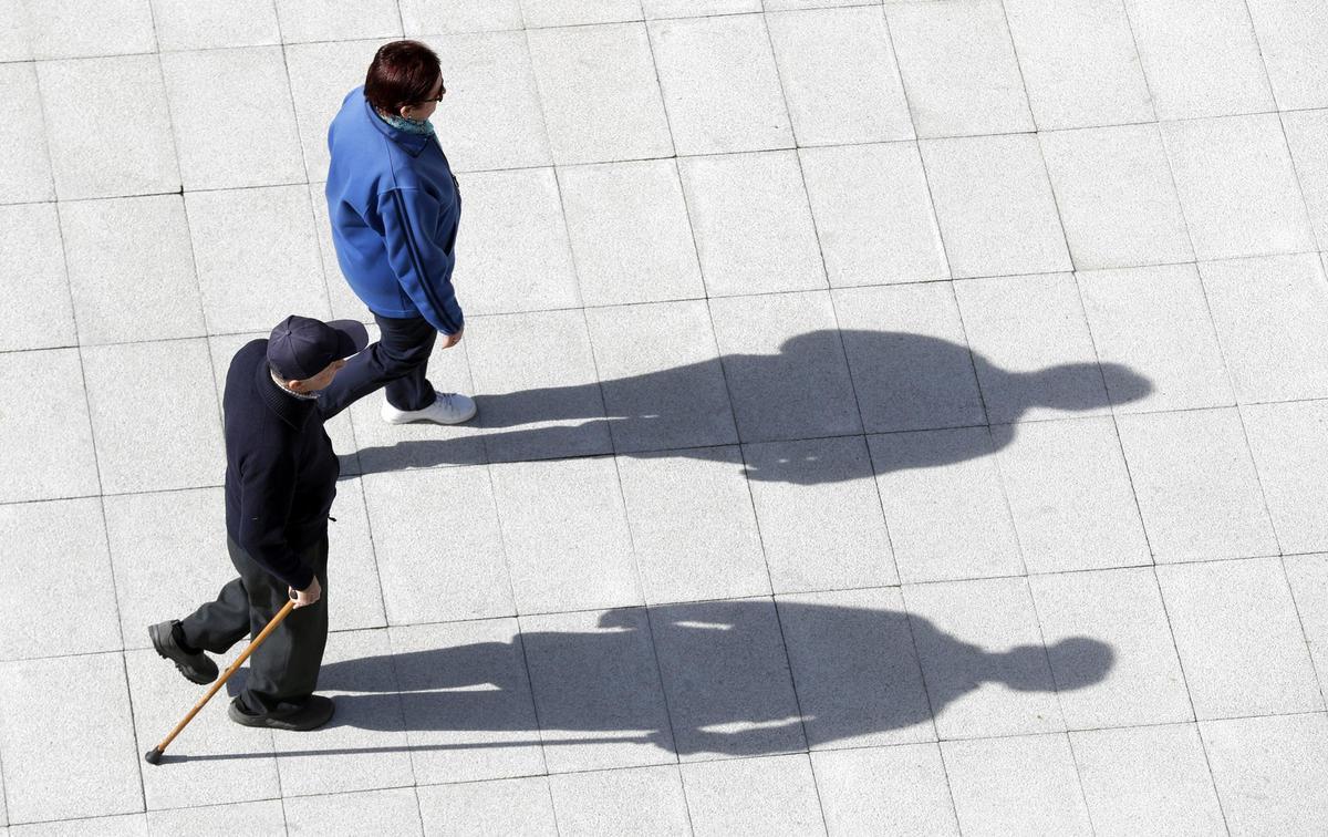 Dos pensionistas caminan por una calle.