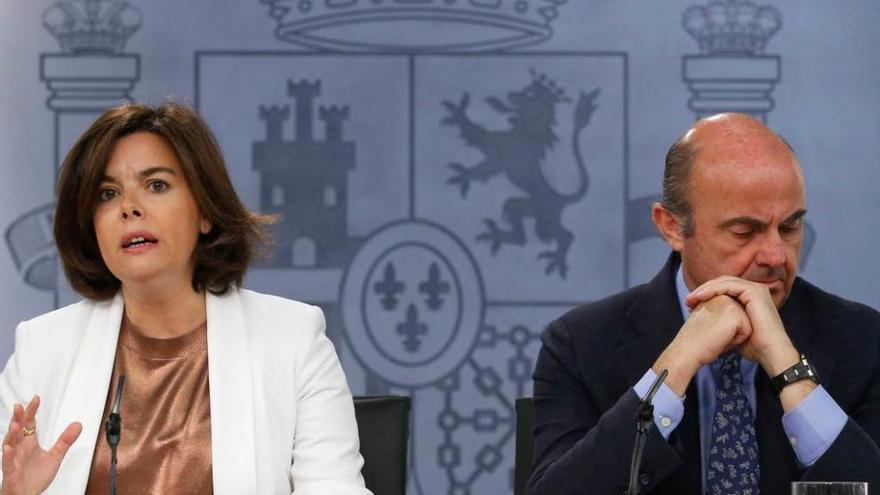 Sáenz de Santamaría y el titular de Economía en funciones, Luis de Guindos, ayer, tras el Consejo de Ministros.
