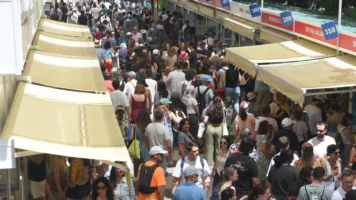 Multitud de lectores pasean por la Feria del Libro de Madrid, en el paseo de Fernán Núñez, en el parque del Retiro.