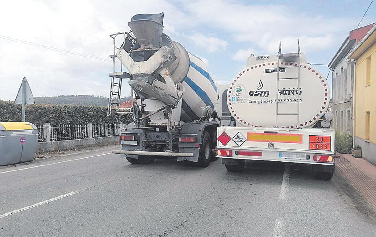 Dos camiones en la AC-542 a su paso por el núcleo de Guiliade