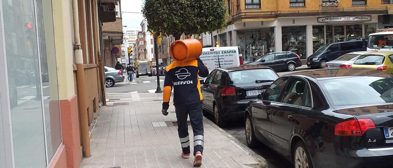 Un repartidor carga con una bombona de butano.