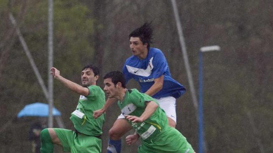 Jairo Cárcaba disputa un balón de cabeza con dos jugadores del Covadonga.