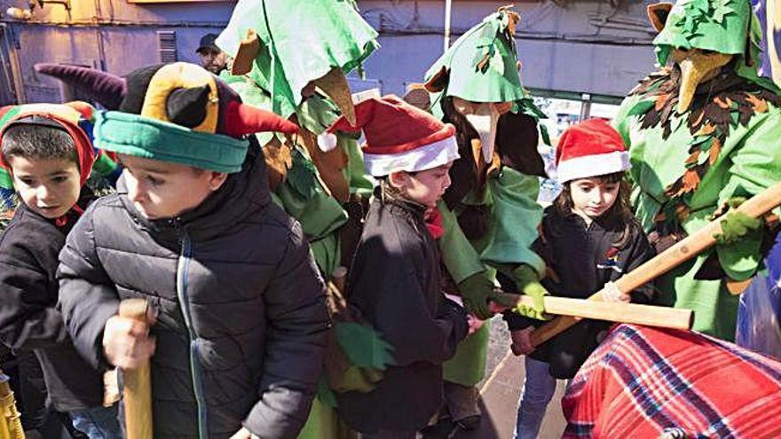 Els singulars personatges dels &#039;tioners&#039;, ajudant els nens i nenes a fer cagar el tió a la plaça, ahir a la tarda