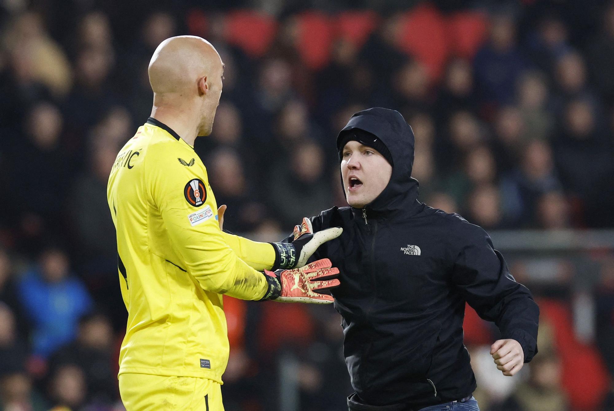 Un espectador salta al campo durante el PSV-Sevilla e intenta agredir a Dmitrovic