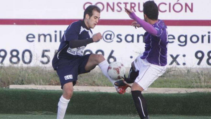 Cristian pelea por hacerse con el esférico ante uno de los jugadores del Palencia C.F.