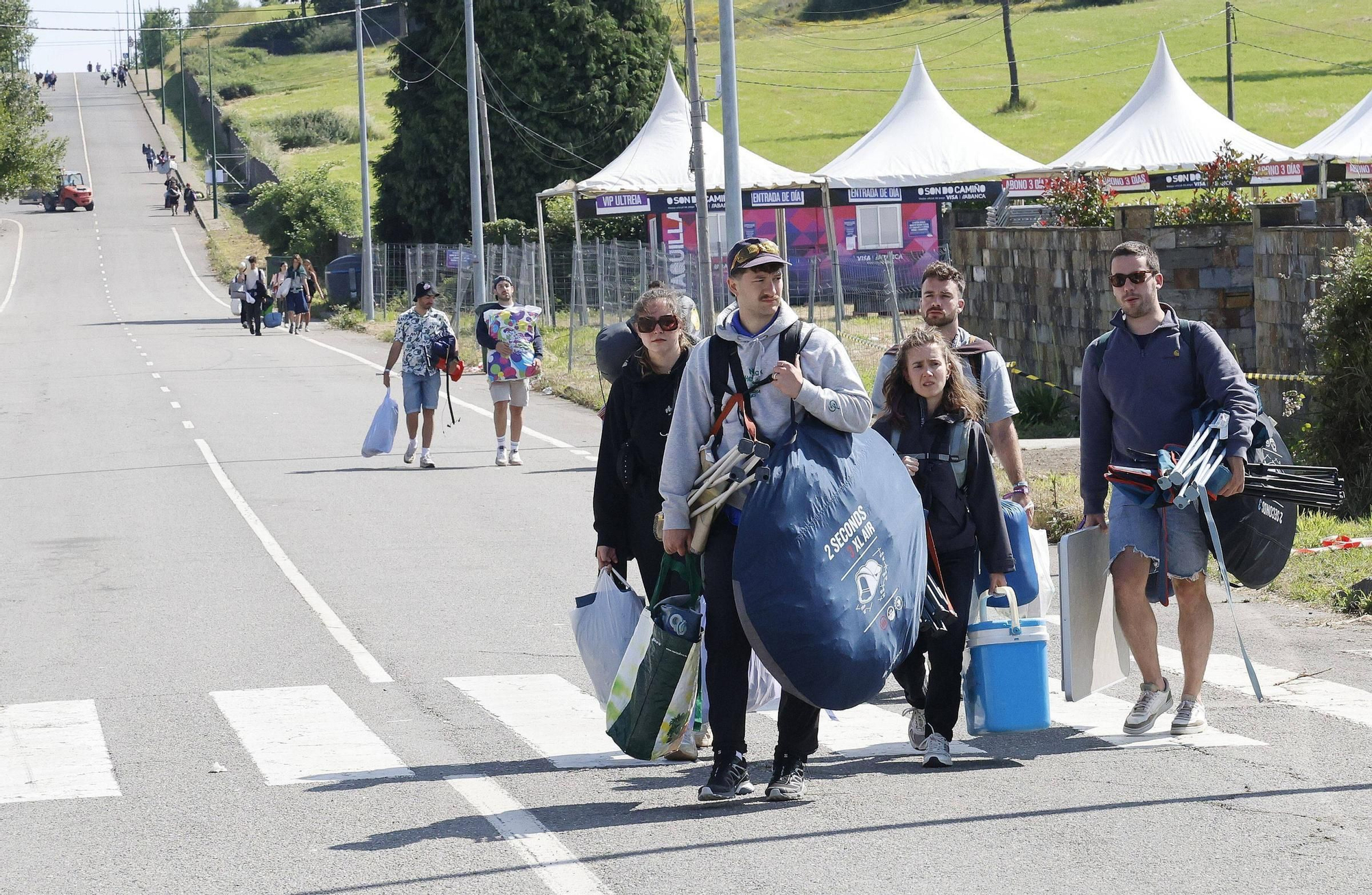 Vuelta a la realidad, paso a paso y mochila a cuestas: los campistas abandonan el Monte do Gozo