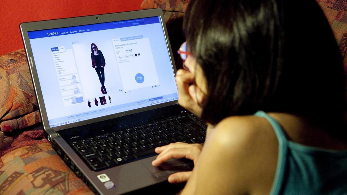 Una joven navega por una página web de ventas 'on line'.