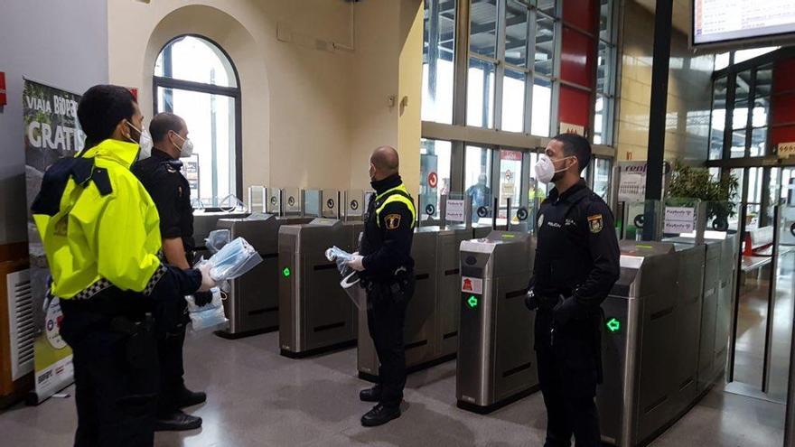 Agentes de la policía repartiendo mascarillas en la estación de tren de Xàtiva, esta mañana