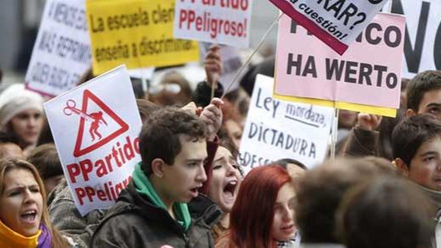 Varios jóvenes sostienen pancartas durante la concentración