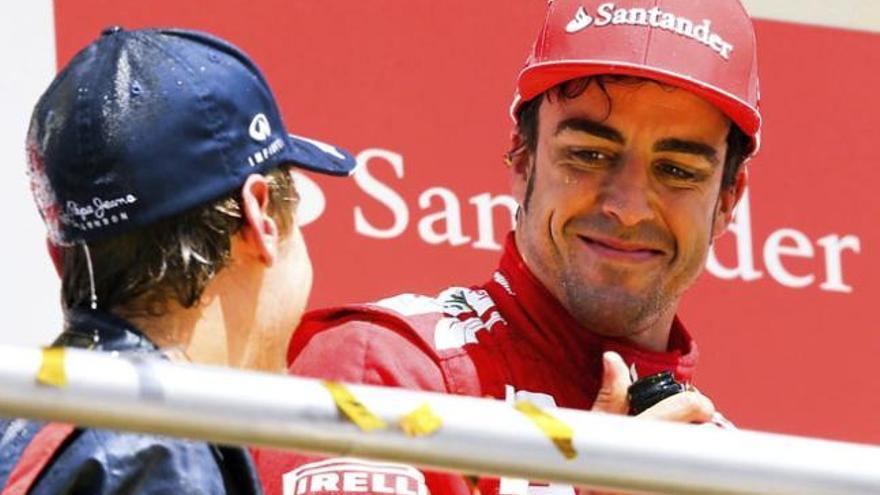 Fernando Alonso sonríe a Vettel en el podium.