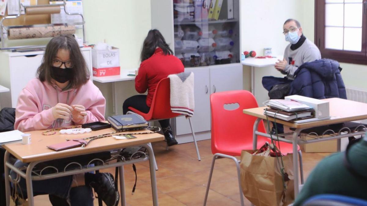 Laura Campo, Tania Alonso y Adrián Vega faciendo un decoráu navidiegu. | Cristina Velasco