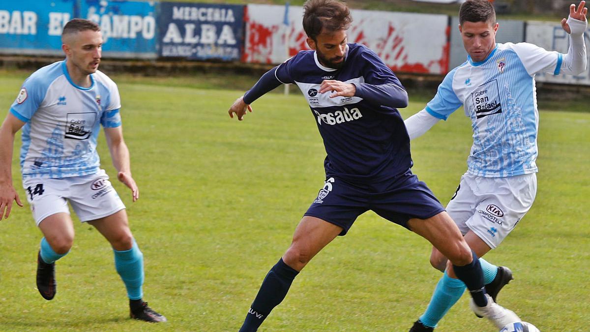 El exfabrilista Nacho Matador protege el balón ante dos rivales durante el Marino-Compos de hace dos jornadas en Miramar. |  // MARA VILLAMUZA