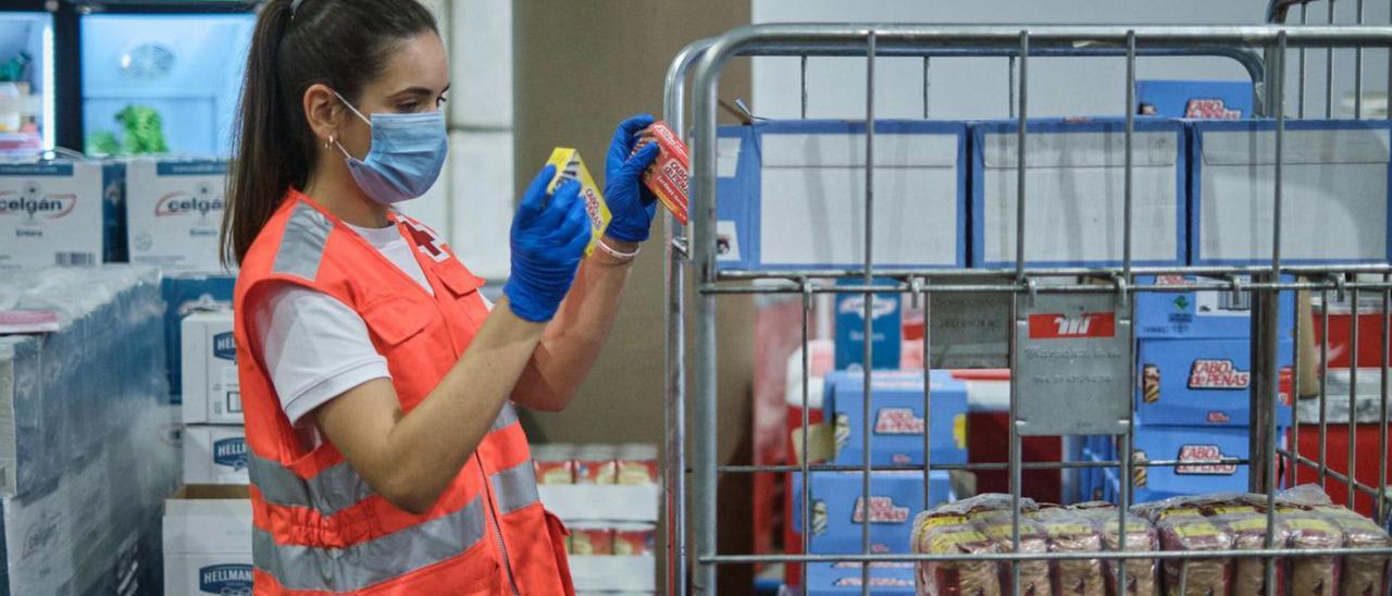 Una voluntaria de Cruz Roja en el Banco de Alimentos del Mayorazgo, en Tenerife. | | ANDRÉS GUTIÉRREZ