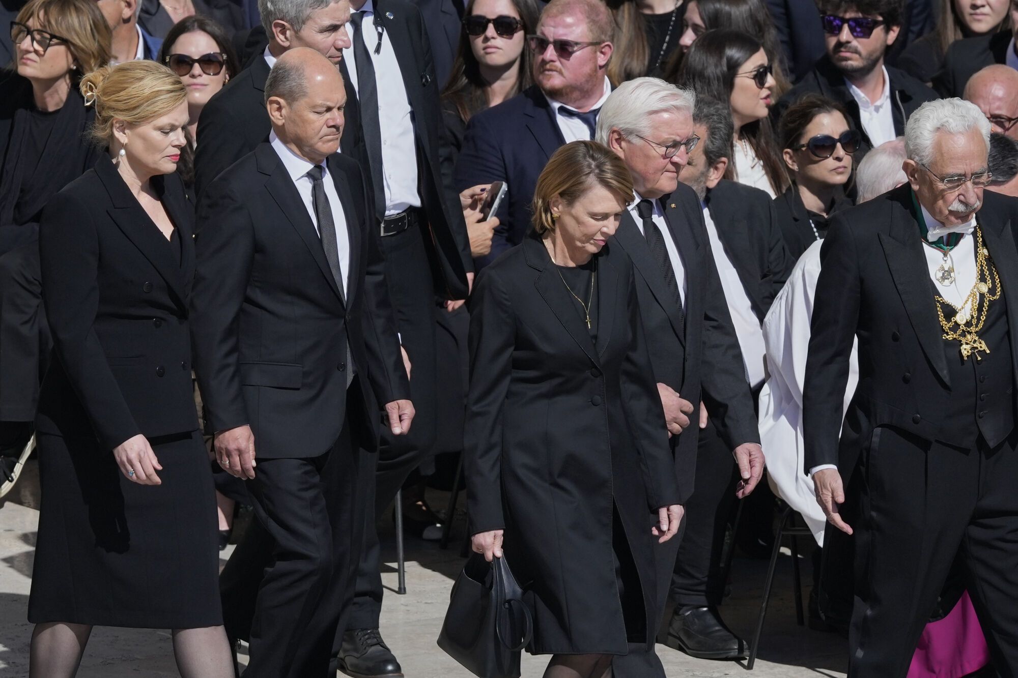 German Chancellor Olaf Scholz, second from left, and wife Britta Ernst follow Germany's President Frank Walter Steinmeier and wife Elke Büdenbender as they arrive for the funeral of Pope Francis in St. Peter's Square at the Vatican, Saturday, April 26, 2025. (AP Photo/Gregorio Borgia)