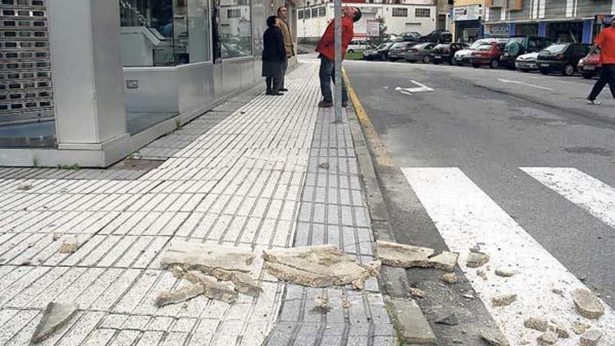 Los trozos de la loseta sobre la acera que cayó ayer al mediodía.