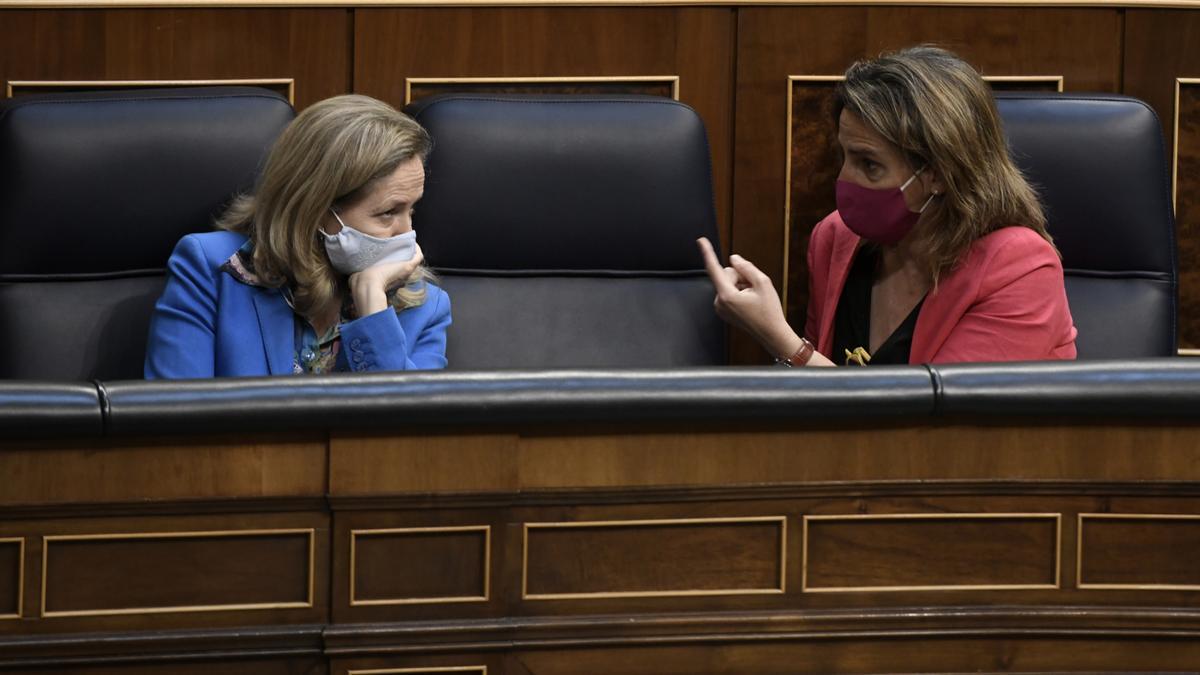 La vicepresidenta primera, Nadia Calviño, escucha a la vicepresidenta tercera, Teresa Ribera, en el pleno de Congreso.