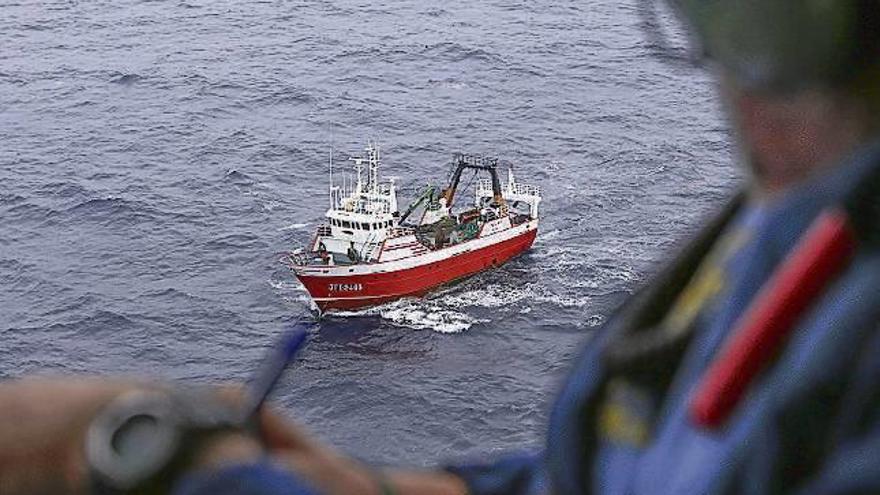 Fernando Berride, a la izquierda, conversa con el piloto Olavide (centro) y el comandante Rodríguez antes de partir de la base de Celeiro. Planifican la ruta a realizar para desarrollar su labor de inspección pesquera y calculan el tiempo para el trayecto que llevarán a cabo.