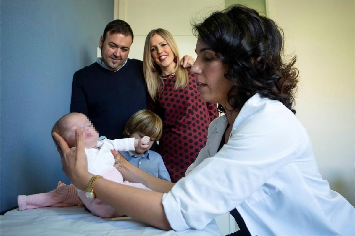 La jefa de la Unidad de Arritmias del Hospital de Sant Joan de Deu, Georgina Sarquella, revisa a María (ante sus padres y hermano mayor). María es el bebé más pequeño del mundo que ha superado con éxito una ablación cardíaca para curarle una taquicardia que sufría desde antes de nacer.