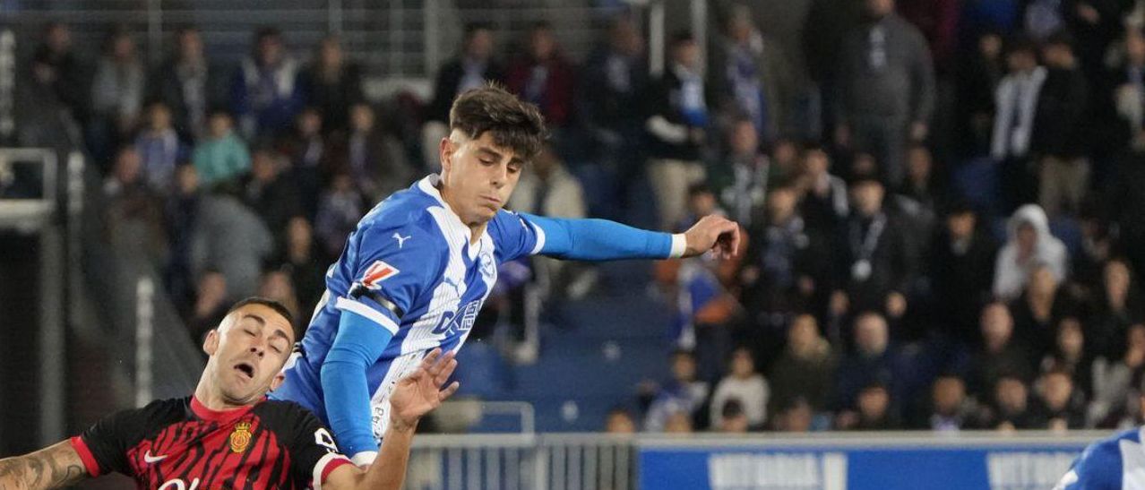 Adrián Pica se impone en el salto a un jugador del Mallorca durante un partido con el Alavés. | EFE