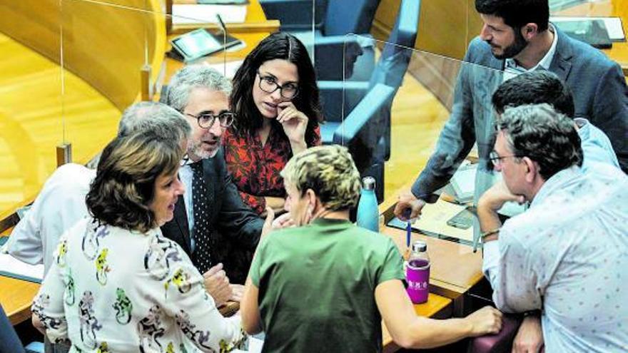 Varios diputados del Botànic conversan con el conseller de Hacienda en las Corts.  | GERMÁN CABALLERO