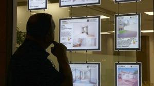 Un hombre mira anuncios de pisos en una inmobiliaria de Barcelona, el pasado día 4.