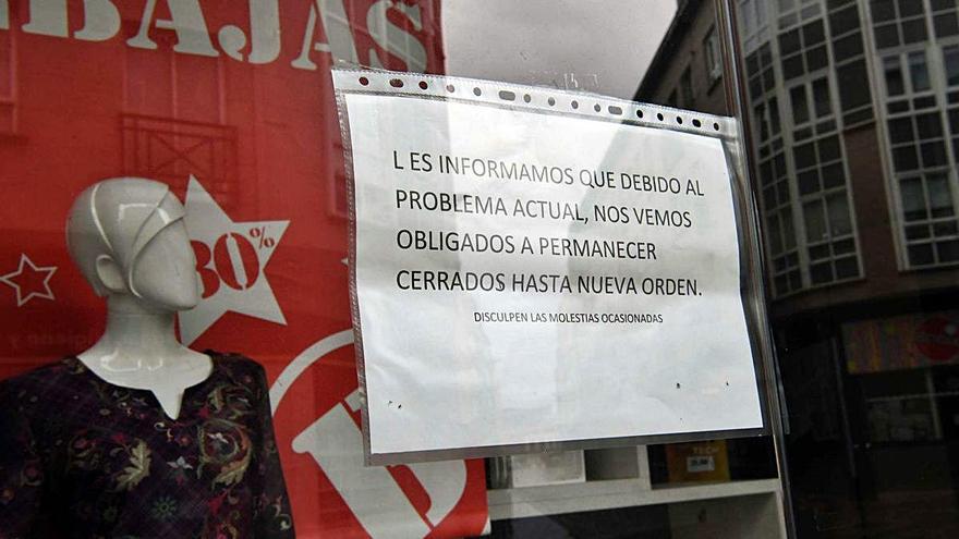 Un comercio de la avenida del Balneario, en Arteixo, con un cartel que comunica el cierre por el coronavirus.