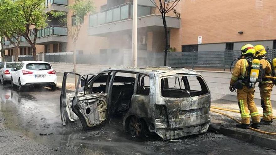 Los bomberos sofocan el fuego en el vehículo, que ha quedado completamente calcinado