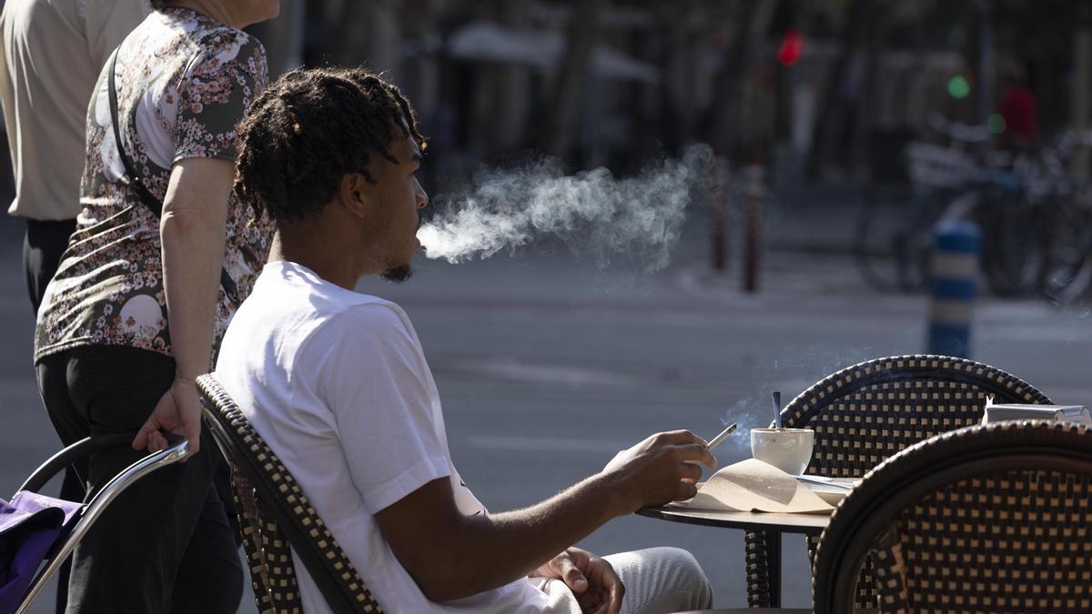 Barcelona 2/11/2022 Prohibición de fumar en las terrazas con la nueva ley anti tabaco Un fumador da una calada a un cigarro en una terraza de un bar en el barrio de Sant Antoni Foto de Ferran Nadeu