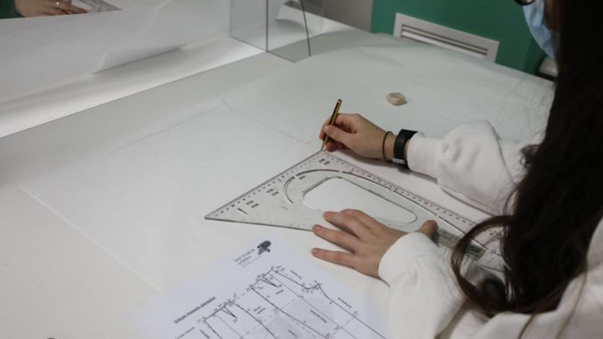 Una joven diseñando una prenda de ropa. 