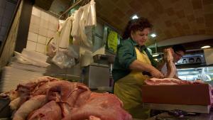 Una carnicera prepara un trozo de panceta en un puesto del mercado de La Boqueria de Barcelona, en una imagen de archivo.