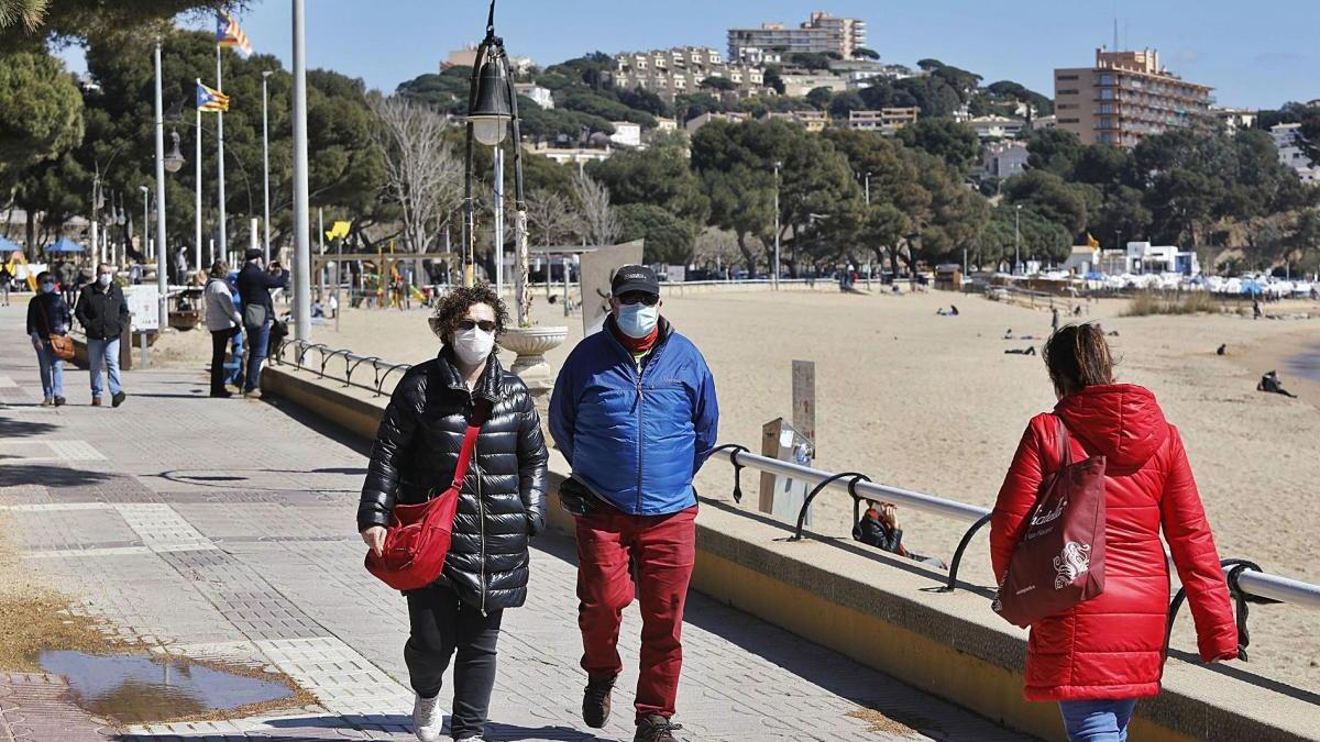 Gent caminant, amb mascareta, pel passeig de Sant Feliu de Guíxols.