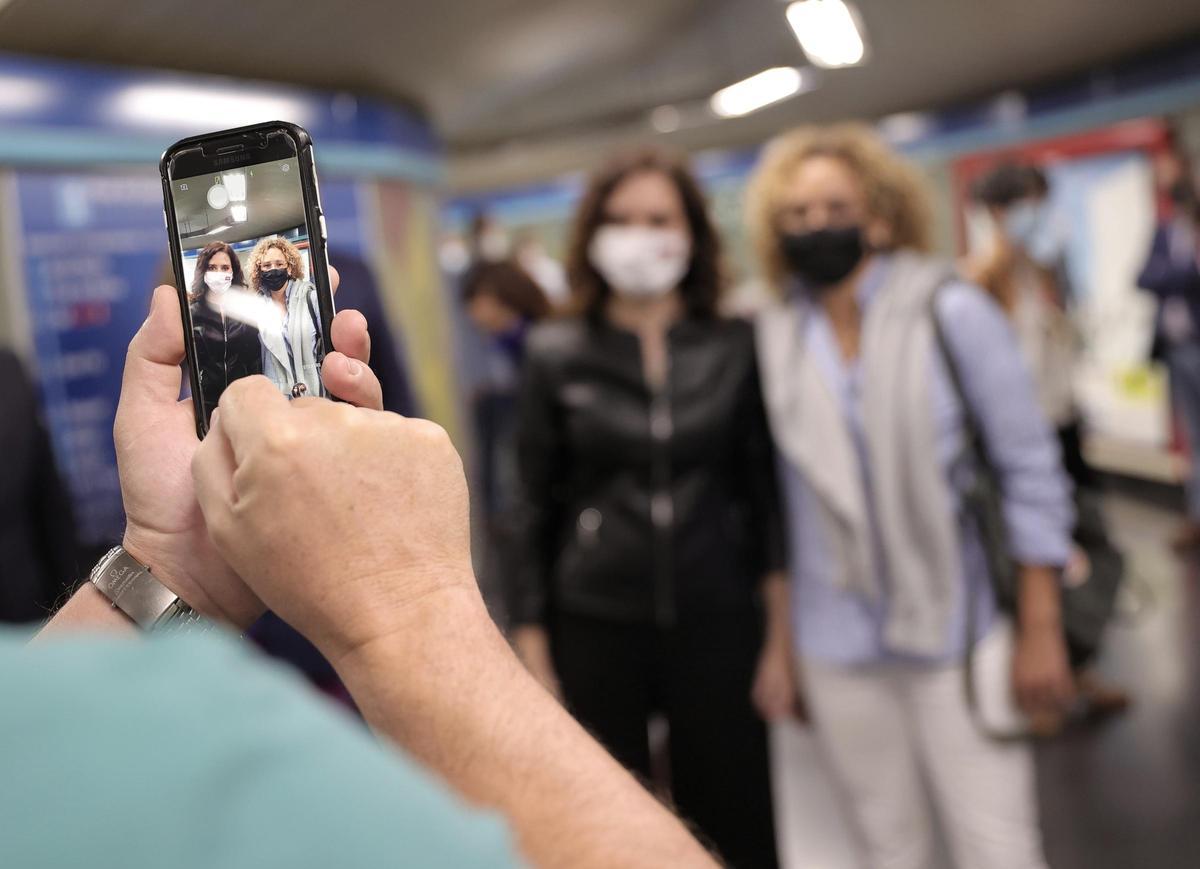 La presidenta de la Comunidad de Madrid, Isabel Díaz Ayuso (i), se hace una fotografía con una seguidora.