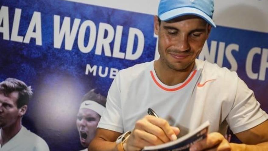 Nadal firma autógrafos en el torneo de exhibición Mubadala World Tennis Championship.