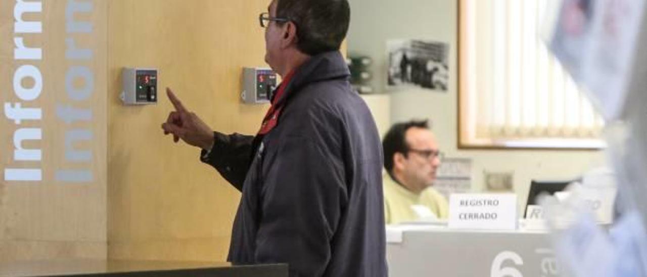 Un trabajador municipal registra su presencia en el Ayuntamiento.