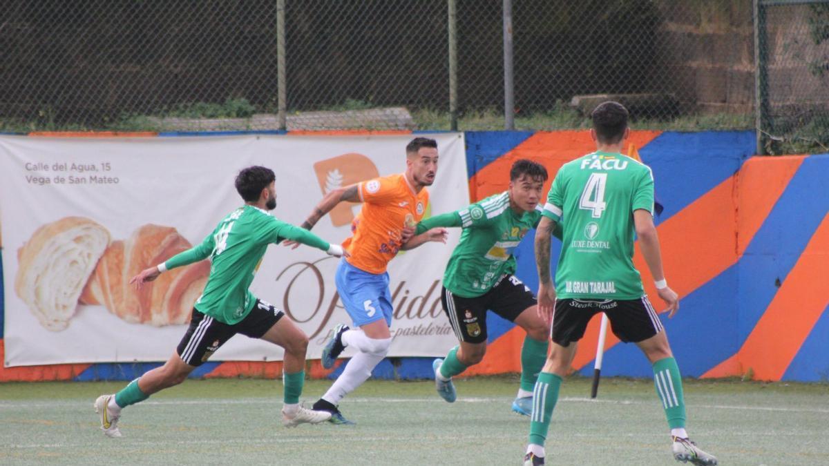 Azael, del Panadería Pulido, rodeado de jugadores del Gran Tarajal